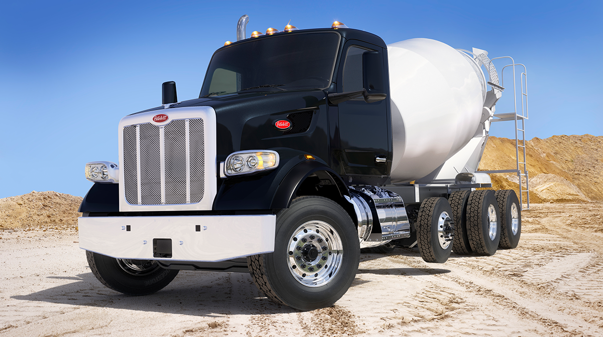 Black Peterbilt Model 567 set-forward mixer on a job site