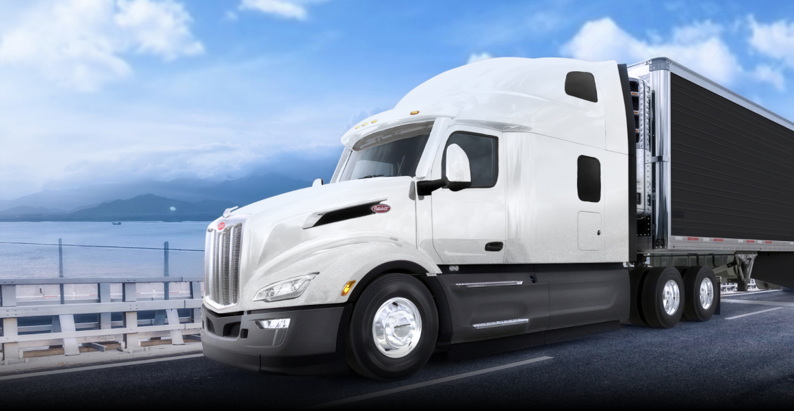 White Peterbilt Model 579 highway tractor crossing a coastal bridge